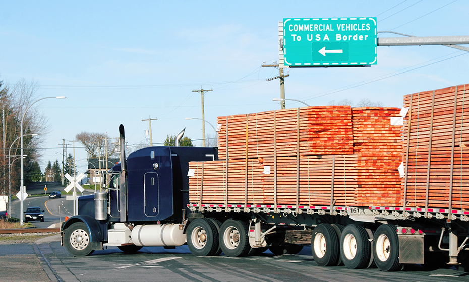 blue flatbed truck transporting wood